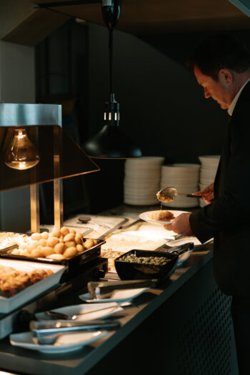 Mann nimmt sich etwas vom Buffet